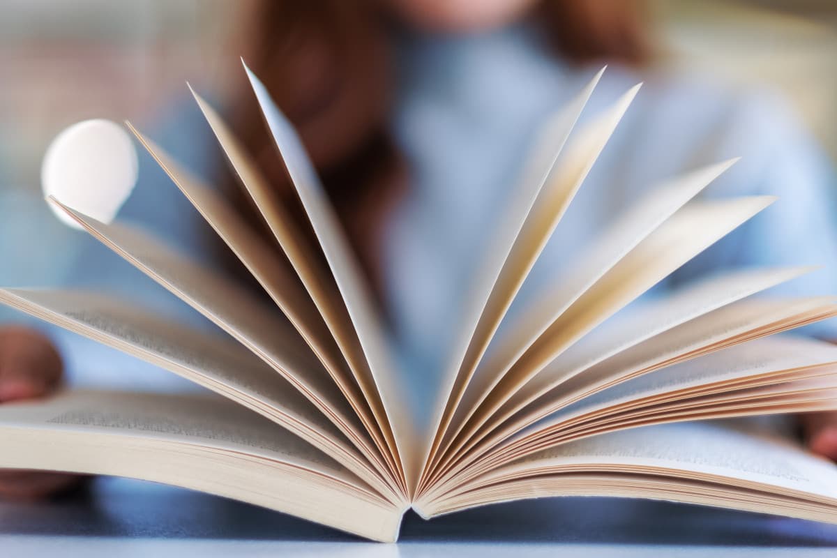 jeune femme tiens un livre dans ses mains